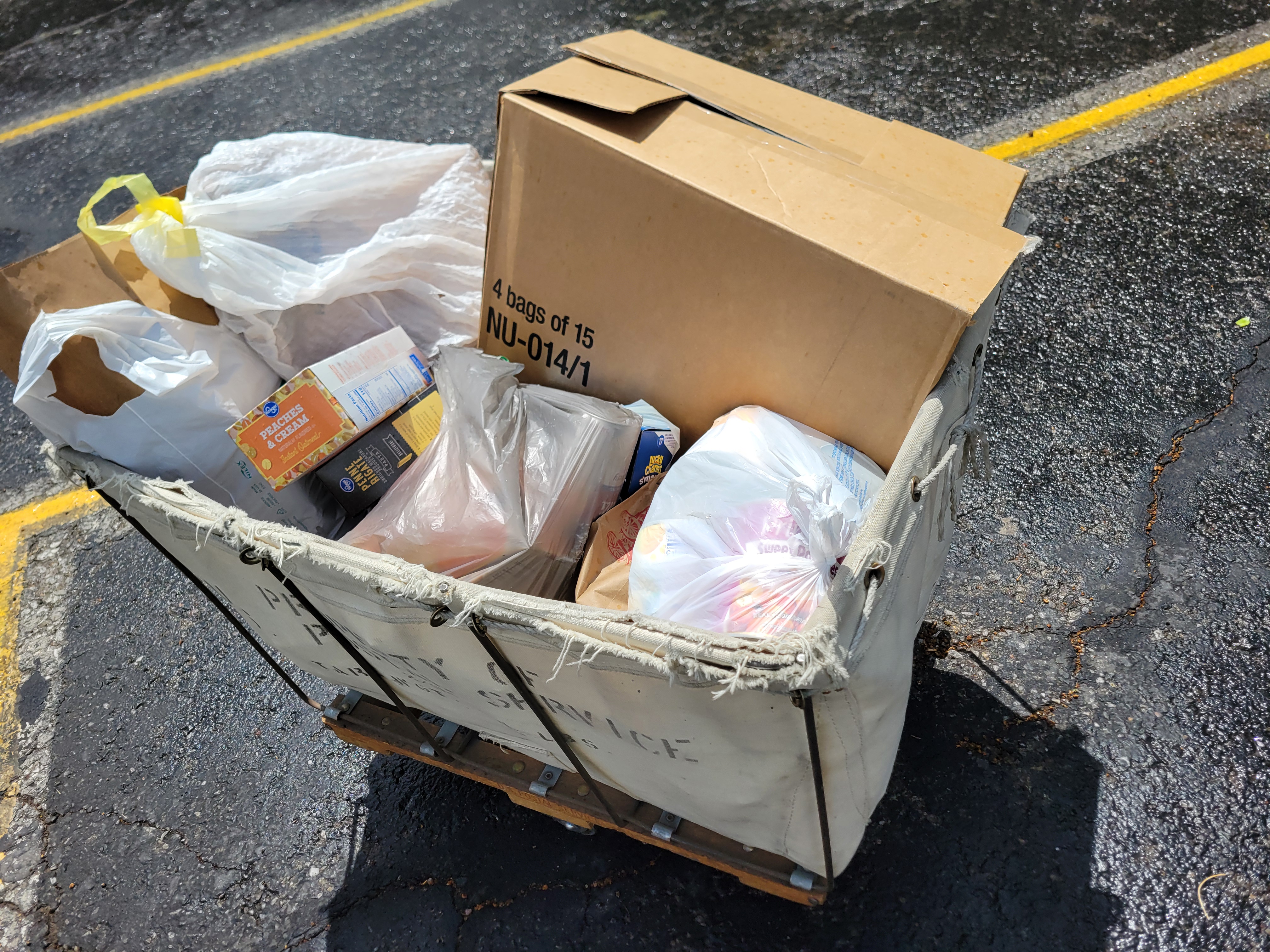 Bags and boxes of dry goods in a mail cart.